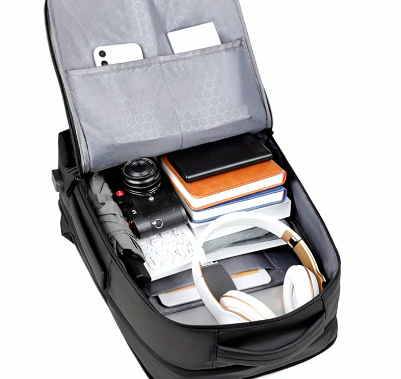 Open backpack packed with a camera, books and headphones